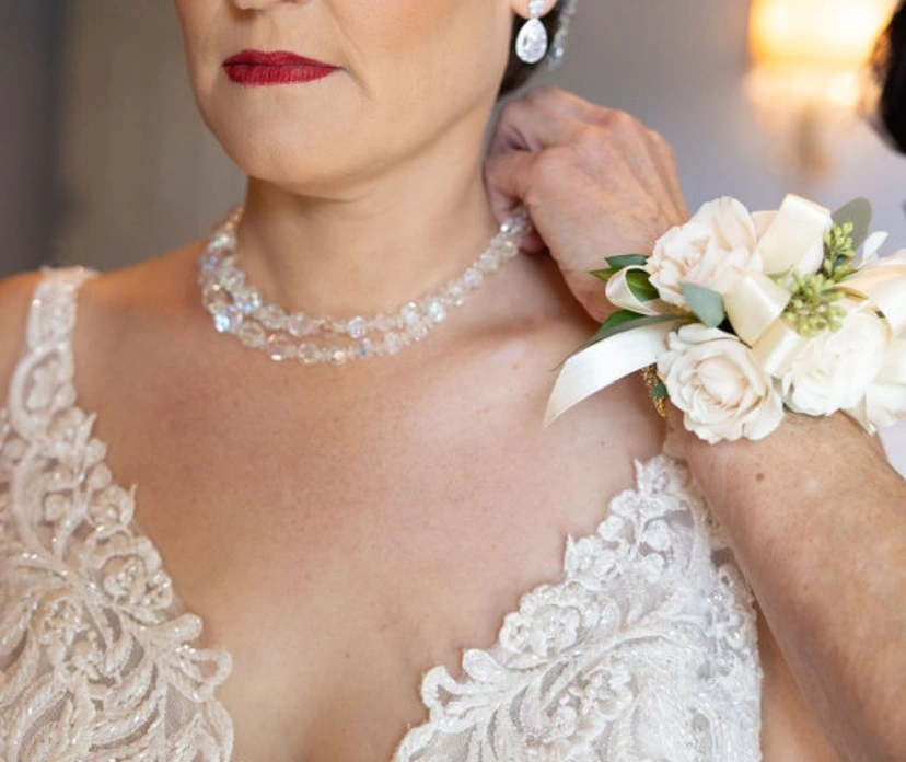 A wrist corsage of cream spray roses worn with a lace gown